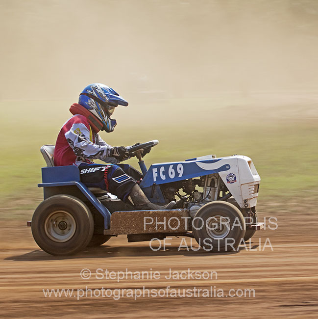 man driving lawn mower in race