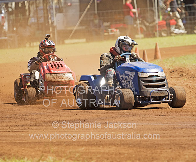 men driving lawn mower in race