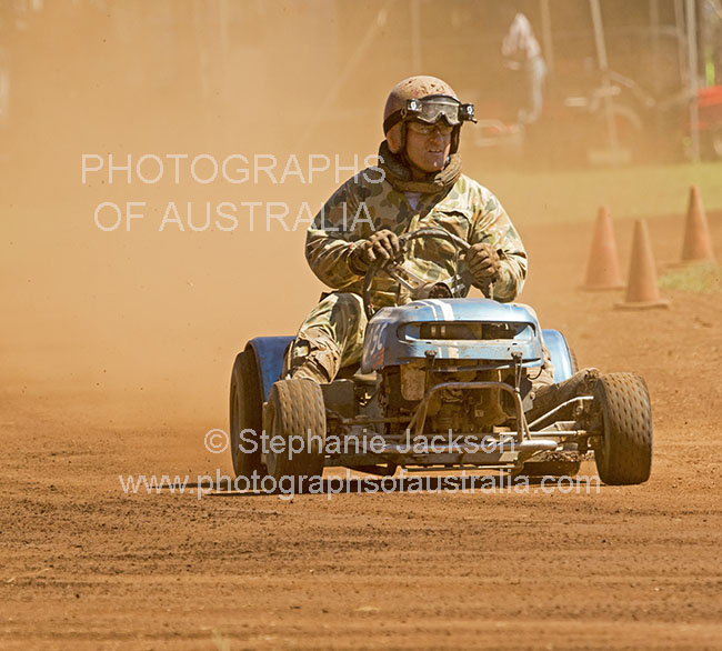 man driving lawn mower in race