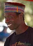 black african man with smiling face wearing colourful hat